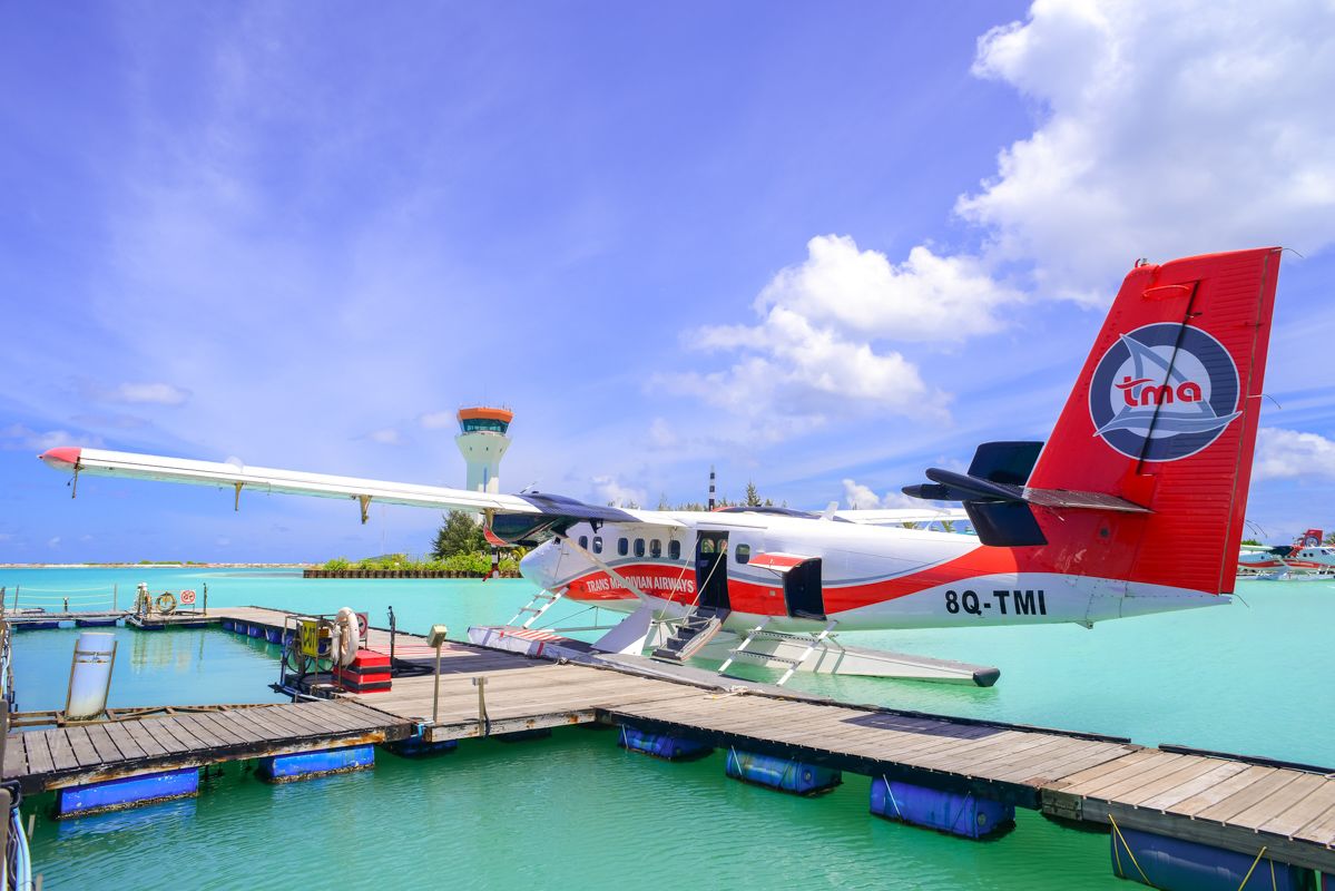 A Red And White Airplane On A Dock