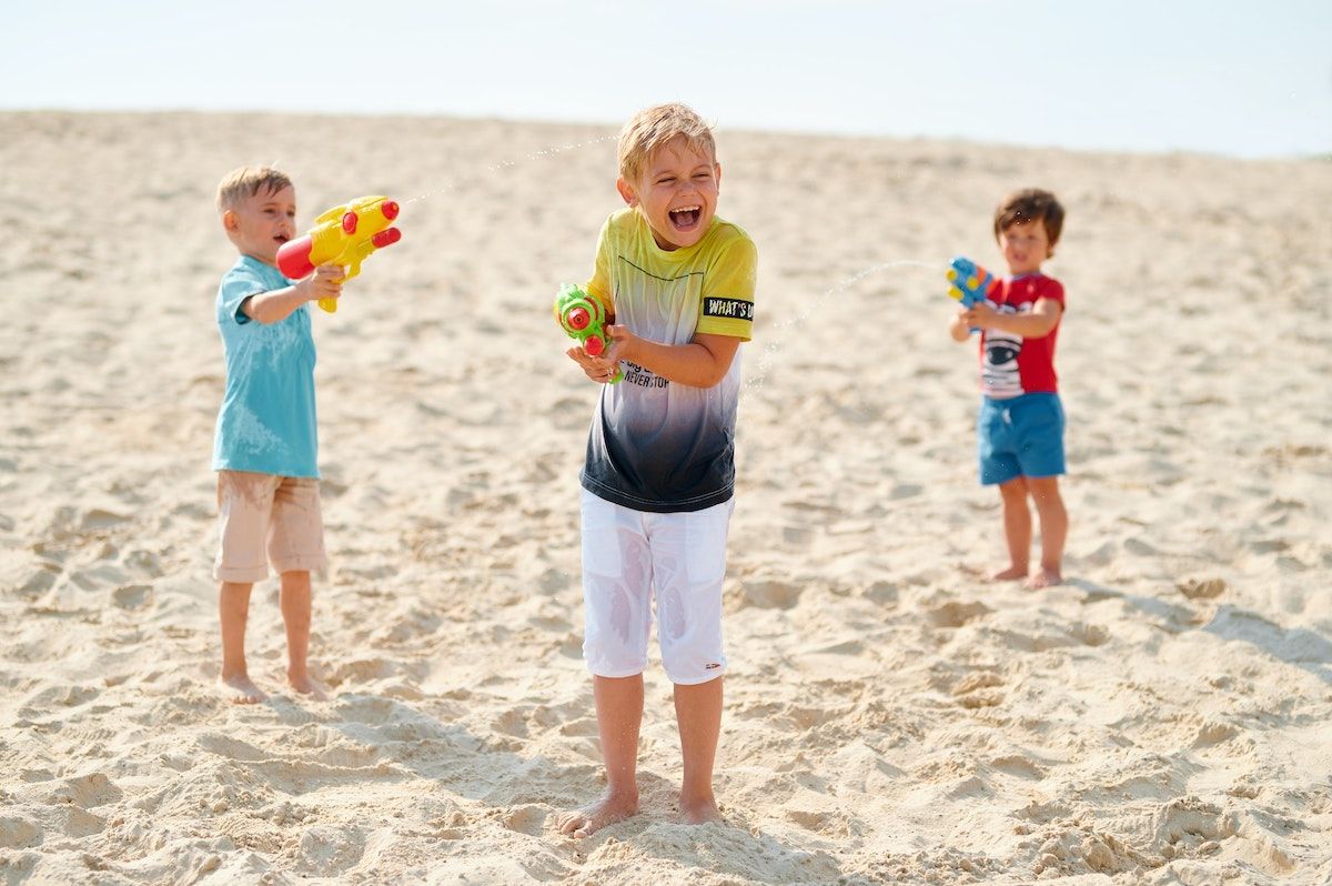 A Group Of Kids Playing On A Beach
