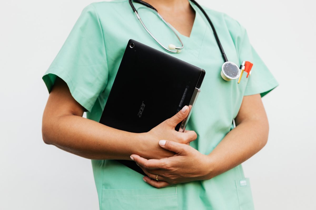 A Doctor Holding A Tablet