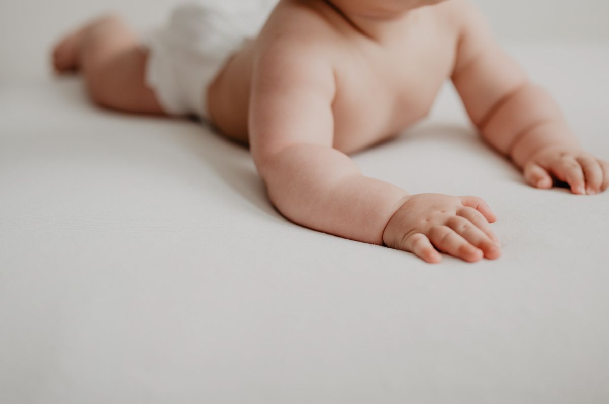 A Baby's Feet On A White Surface