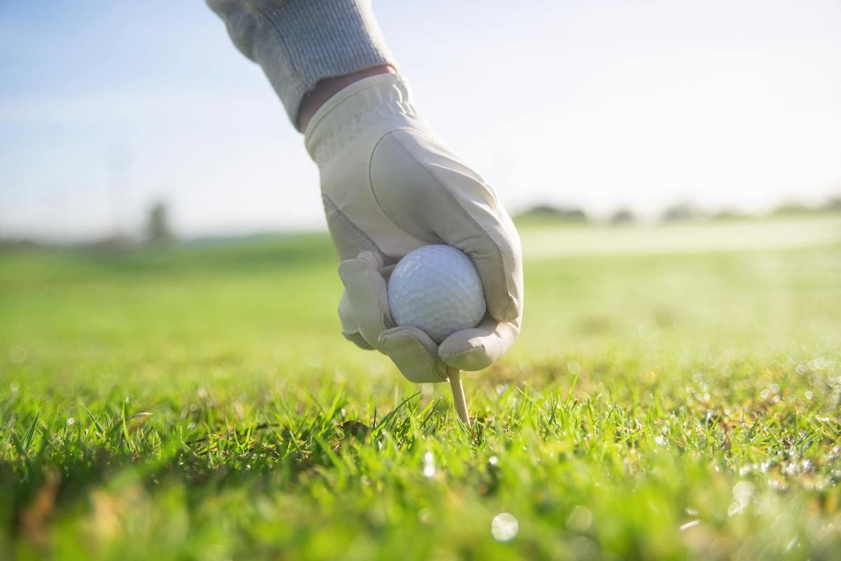 A Person's Hand Holding A Golf Ball